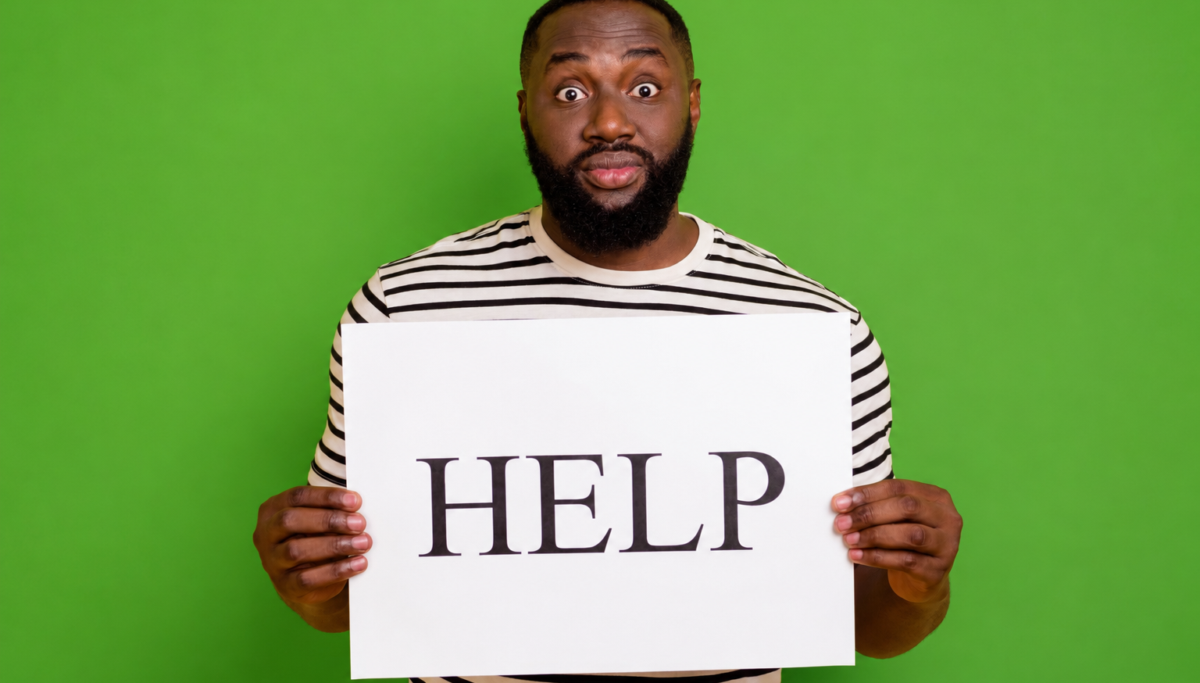Holding up help sign, shocked face, green isolated background