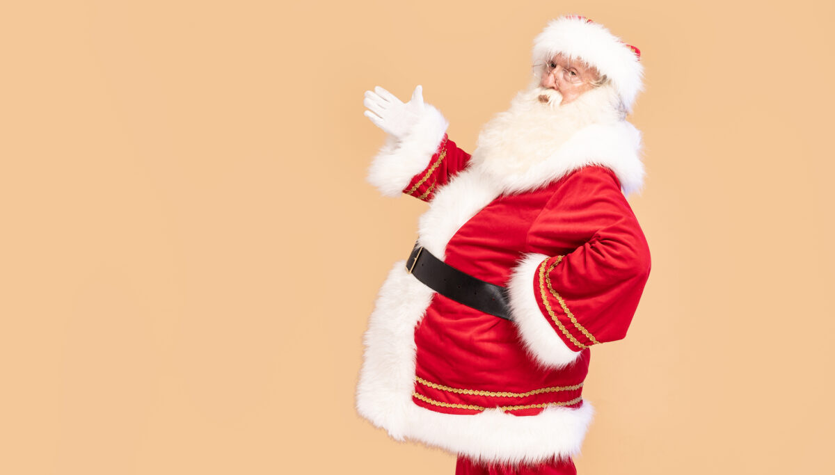 Real Santa Claus posing on beige studio background, big belly