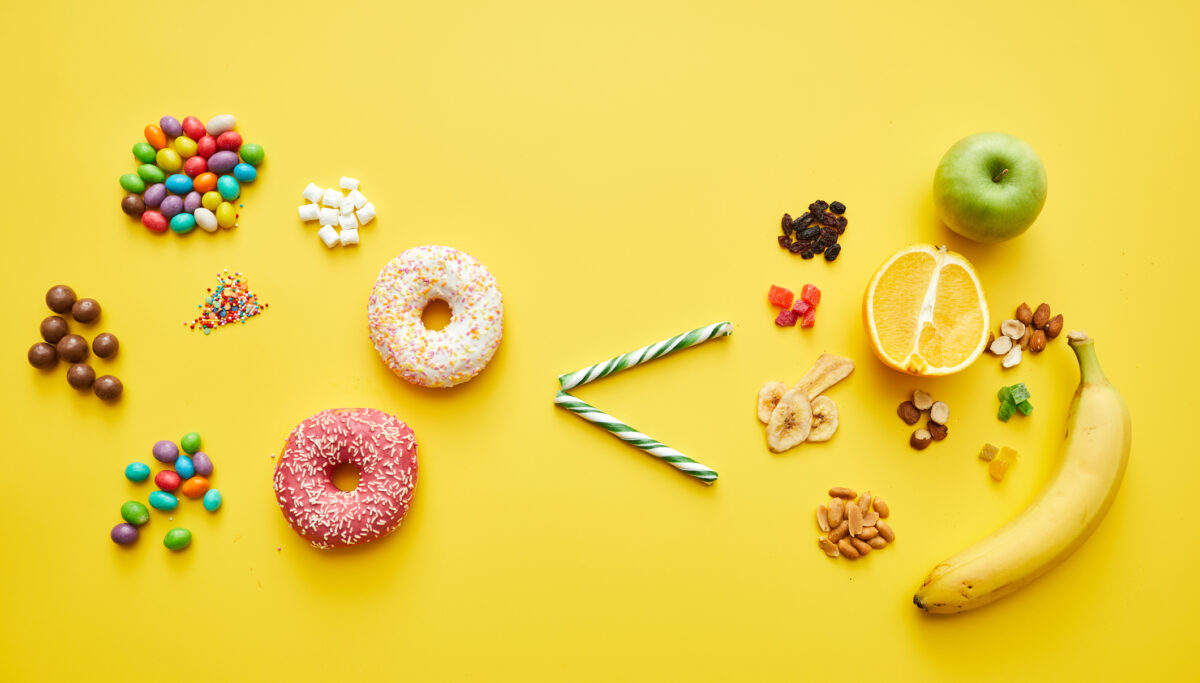 Choosing healthy sugar concept: sweets and baked food is less than fresh and dried fruits on bright yellow background