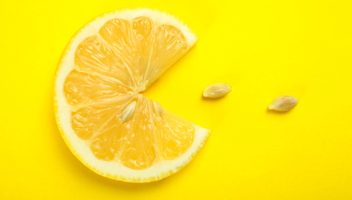 Round piece of fresh ripe lemon on yellow background.