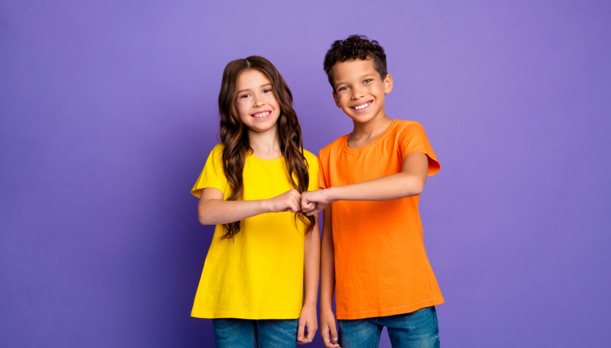 Photo portrait of cute little boy girl fist bump friends dressed stylish yellow orange clothes isolated on purple color background