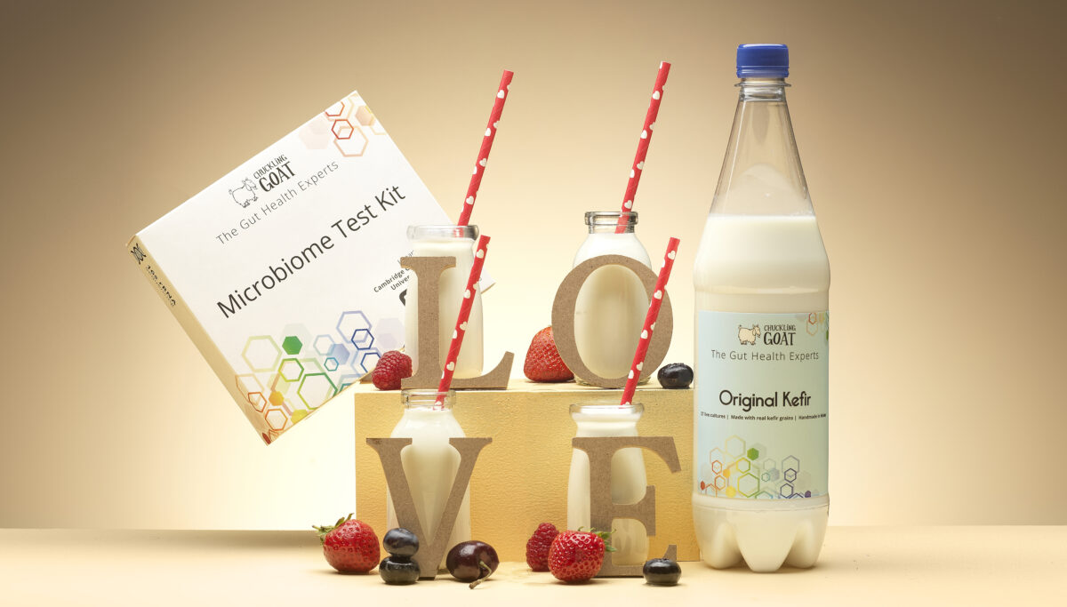 Who needs love? You do! Image of LOVE sign with bottles of kefir and microbiome test. Love your gut! Yellow background.