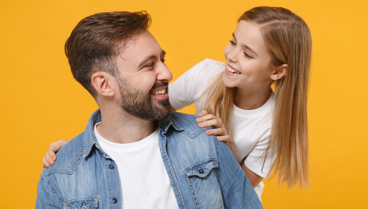 Funny bearded man in casual clothes have fun with cute child baby girl. Father little kid daughter isolated on yellow background. Love family day parenthood childhood concept. Looking at each other.