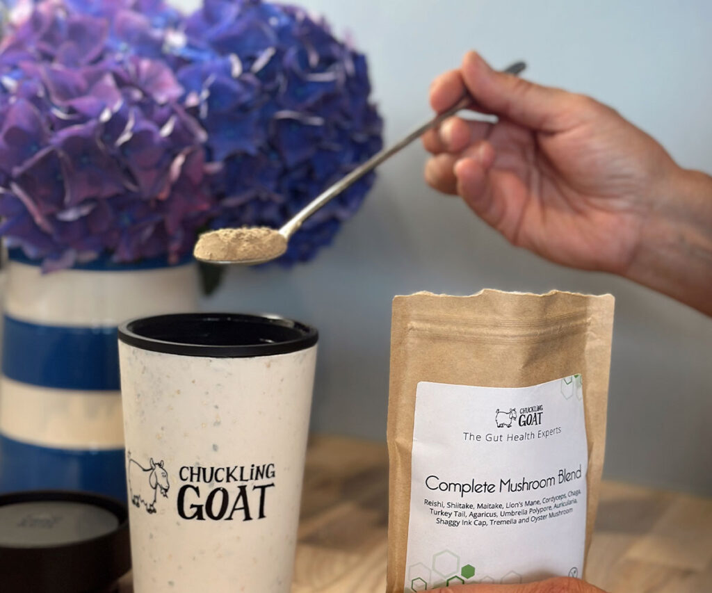 Image of Chuckling Goat Mushroom Powder being added to Chuckling Goat Travel mug.