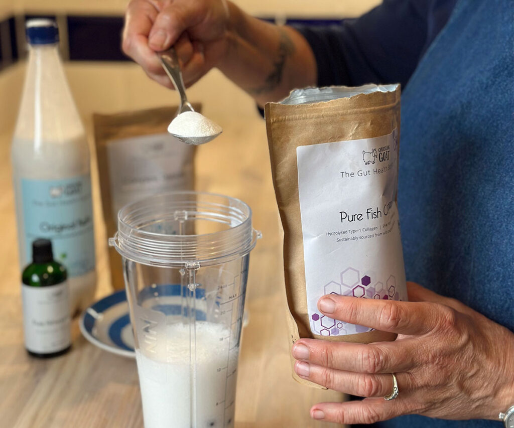 Image of Chuckling Goat Pure Fish Collagen being added to a glass of kefir milk. Close up image of packet in Shann Jone's hand.