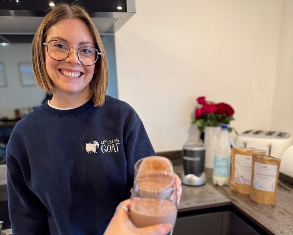 Image of Ceris, Chuckling Goat Director, drinking a gut health smoothie, smiling.