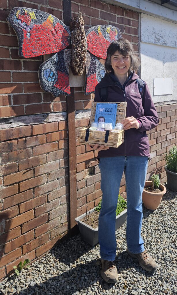Woman at Clynfyw Care Farm, holding a wicker box donated by Chuckling Goat containing lotions and soaps.