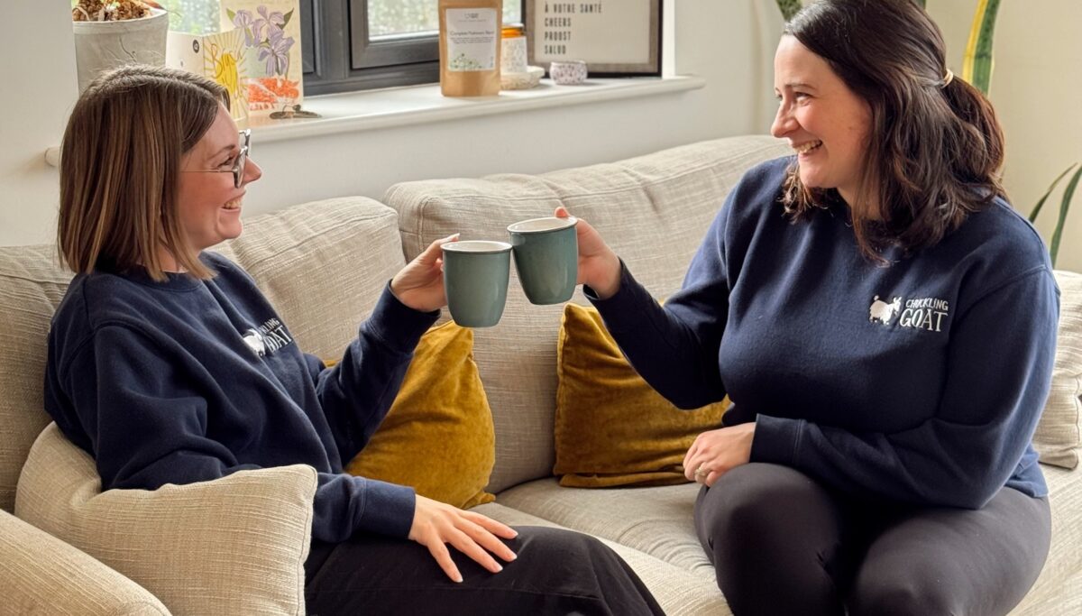 Image of Ceris and Emily, Chuckling Goat staff members, cheersing with a cup of Mushroom Blend coffee.