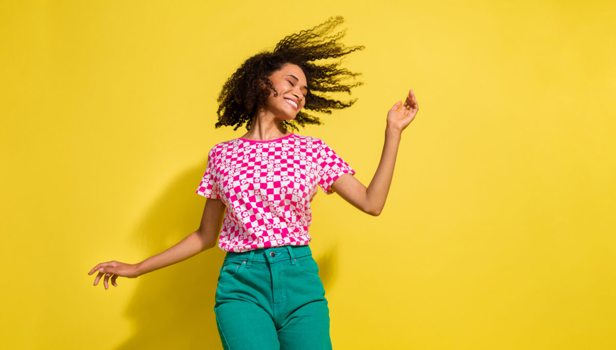 Portrait of carefree cheerful person dancing on yellow colour background.