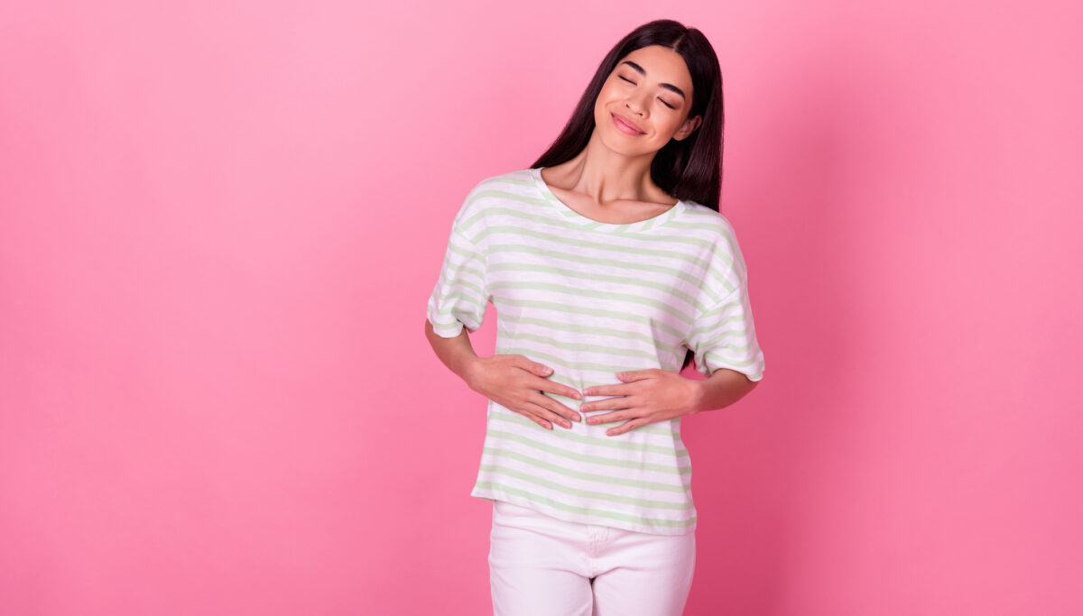 Photo of satisfied person closed eyes arms touch stomach isolated on pink colour background.
