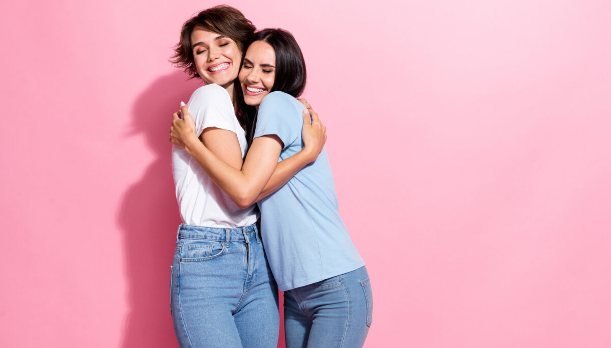 Portrait of two funky girls hugs together lovers perfect match lesbians carefree support sweetheart isolated on pink color background.