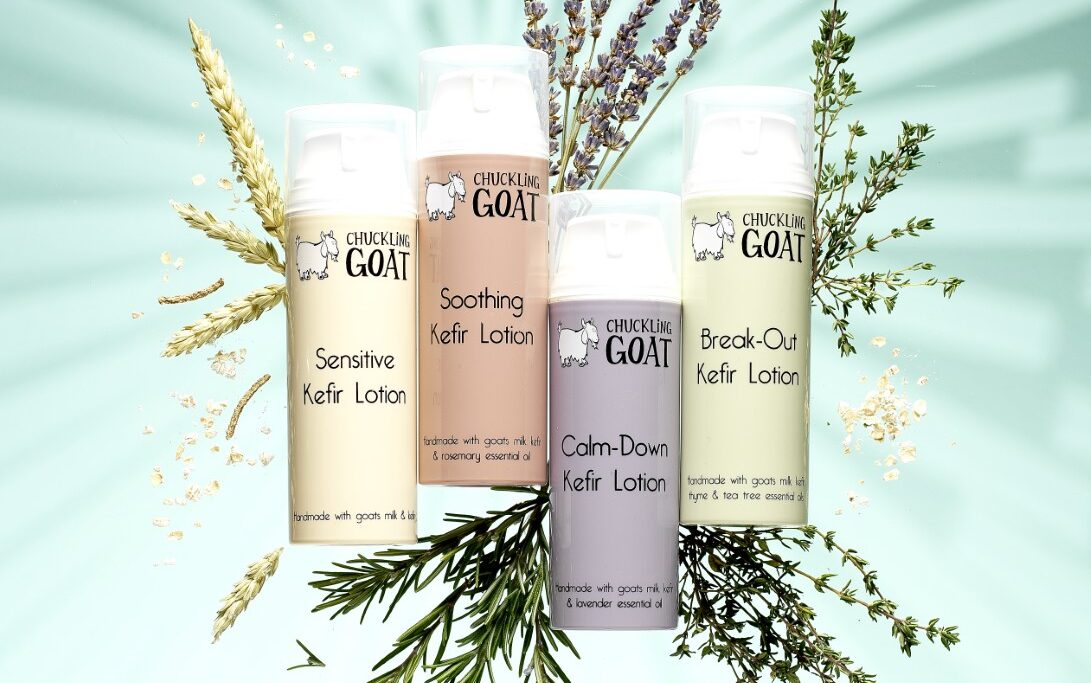 Image of 4 different Chuckling Goat probiotic lotions on bright blue/green background.