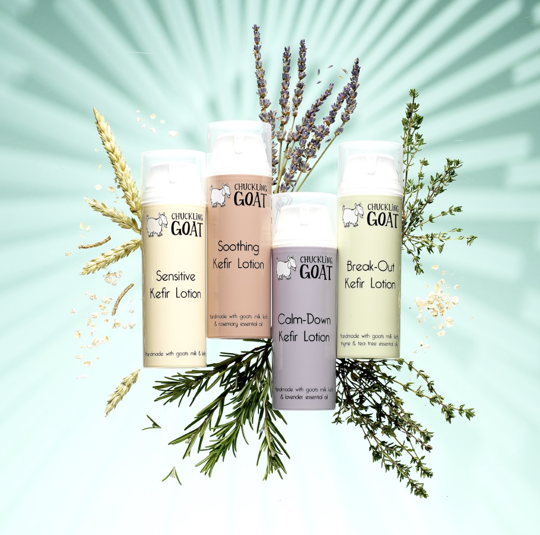 Image of 4 different Chuckling Goat probiotic lotions on bright blue/green background.