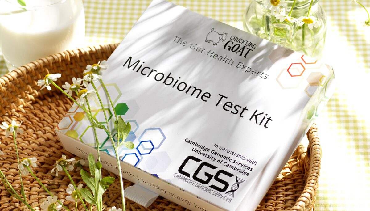 Photo of Chuckling Goat Microbiome Test and glass of Kefir with flowers in the background.