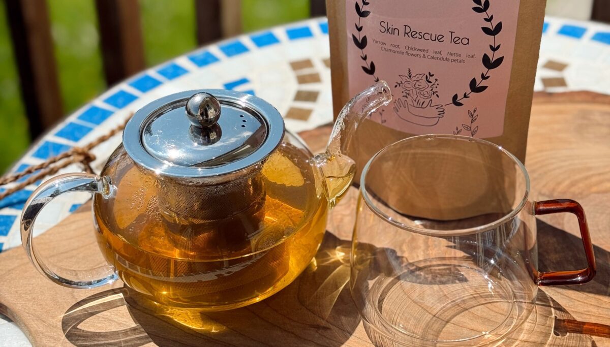 Image of Chuckling Goat Skin Rescue Tea and Chuckling Goat teapot on table outside.