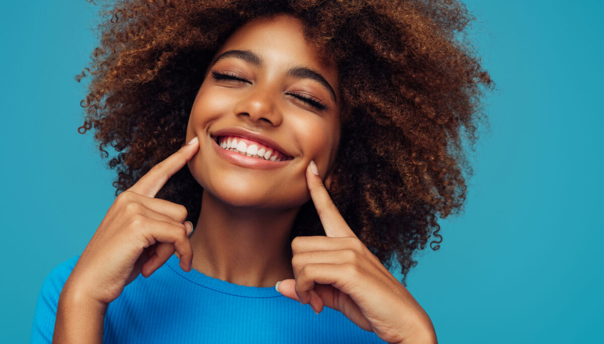 Beautiful woman with clear skin on blue background