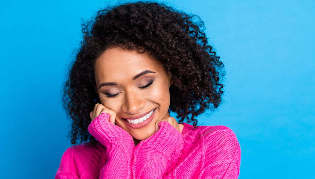 Happy woman smiling on a blue background.