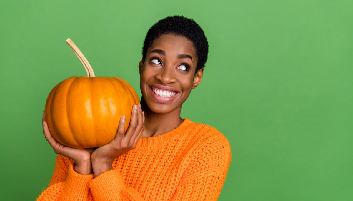 Photo of short hairdo lady with pumpkin look promo wear orange pullover isolated on green color background.