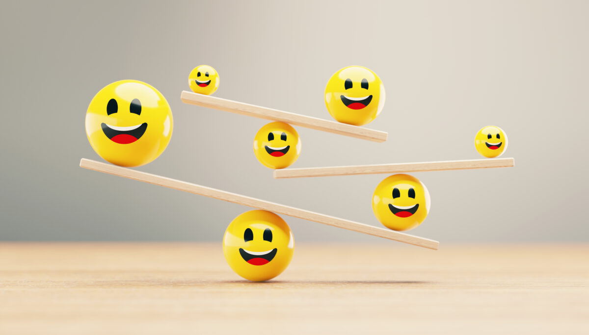 Image of smiley face emoji balls balancing on tower of see-saws