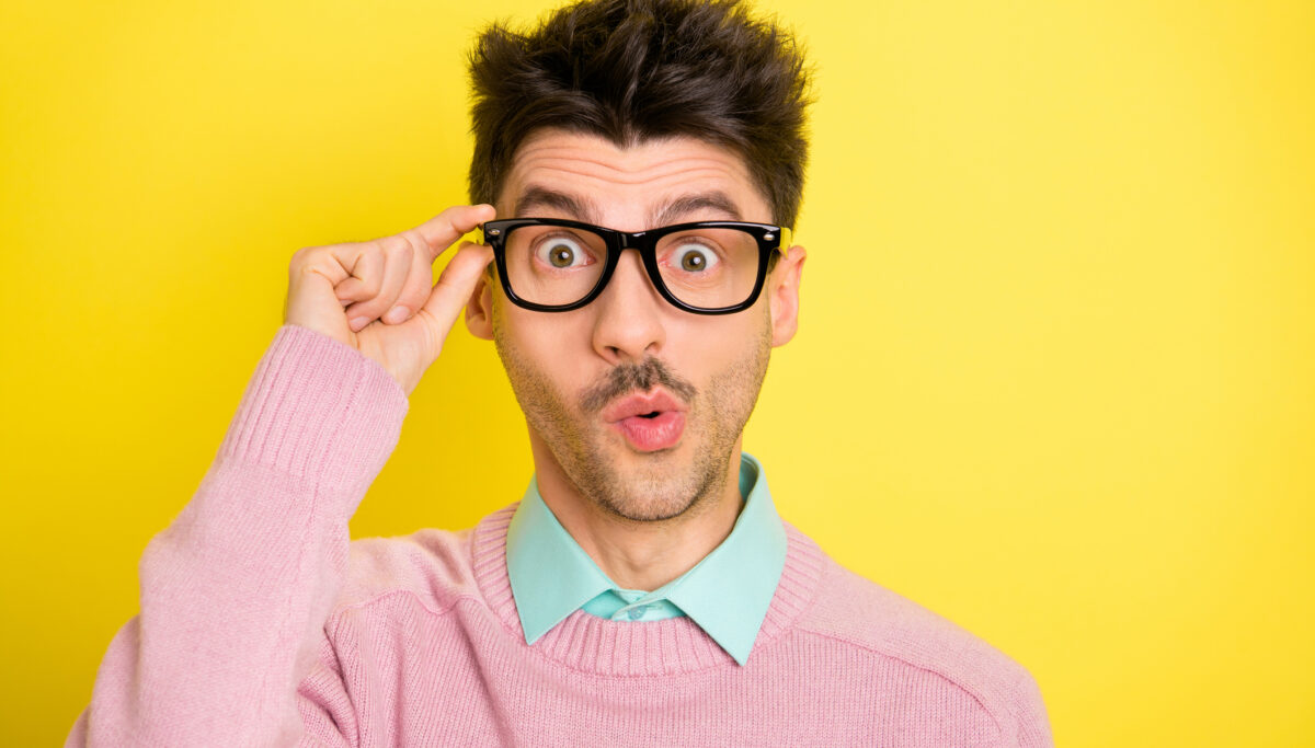Photo of young handsome serious shocked amazed surprised man in funky glasses isolated on yellow color background