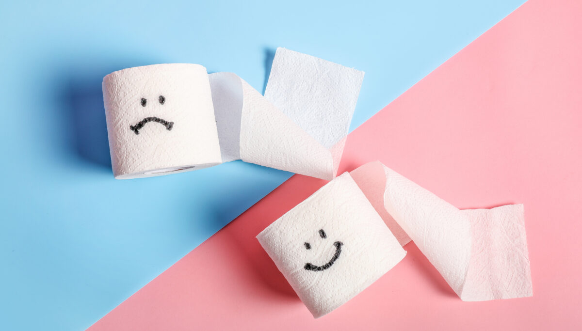 Toilet paper rolls with happy and sad smilies on pink and blue background