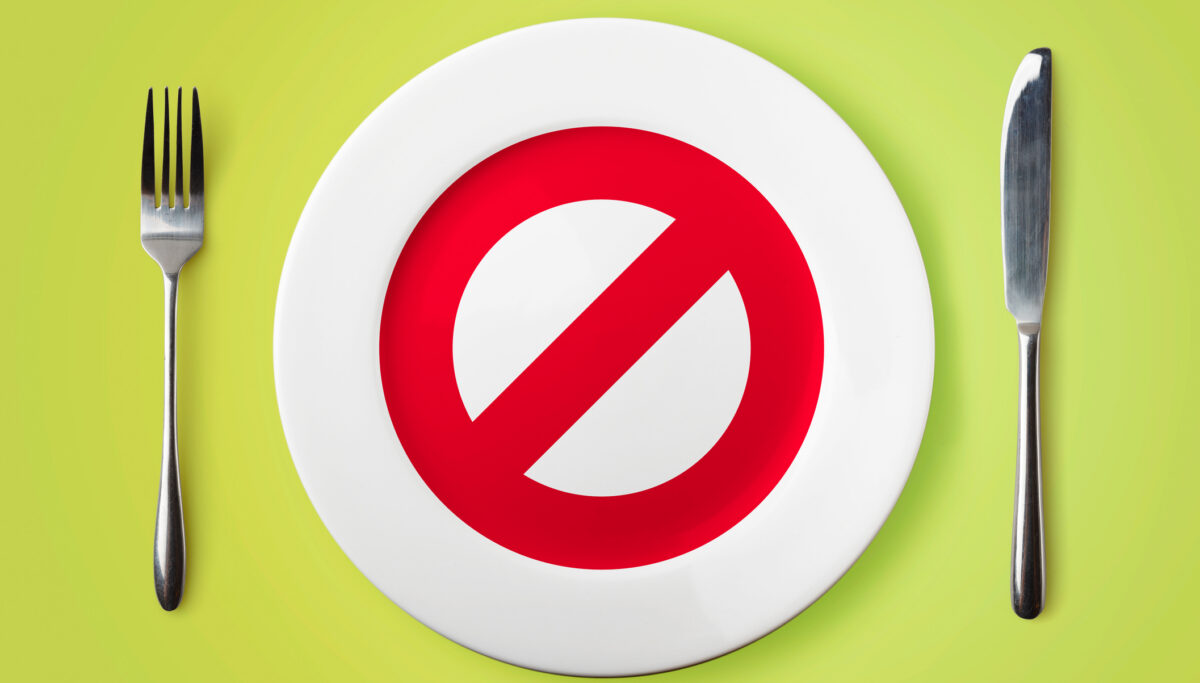 Empty plate with restricted red sign on it - dieting concept image