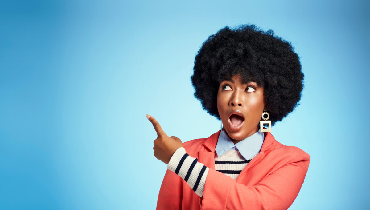 Woman pointing upwards, shocked face, wow, blue background