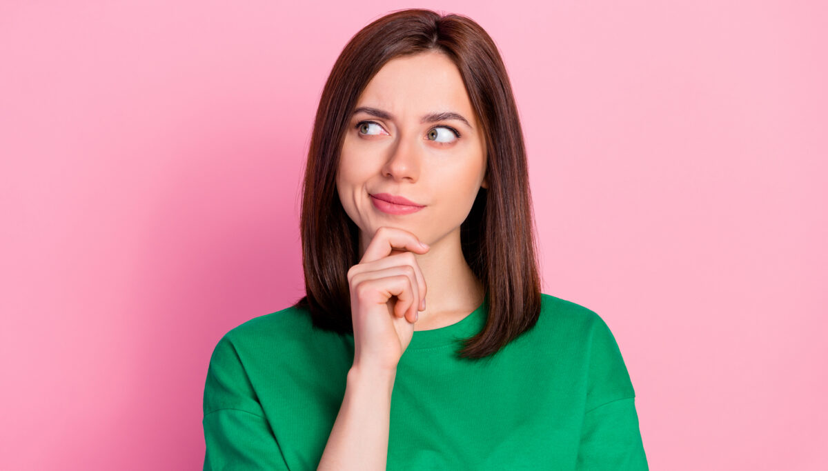 Photo portrait of nice young lady skeptical look empty space not believe doubt dressed trendy green look isolated on pink color background
